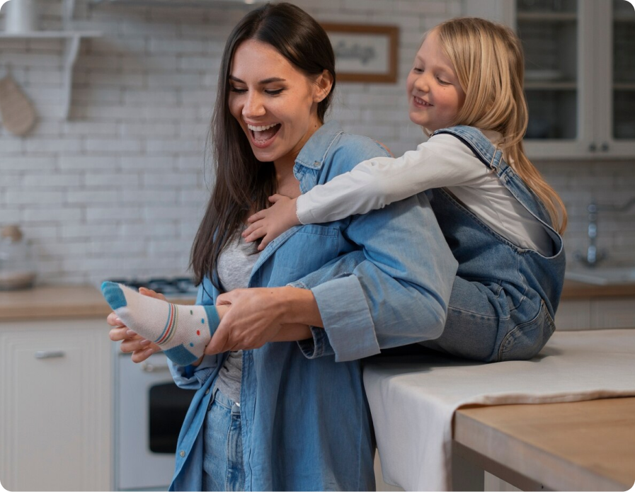 A mother and daughter laughing in the kitchen in a safe, secure home